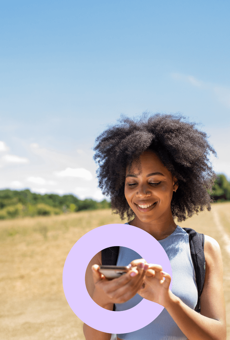 A smaller version of lady looking at phone in English countryside