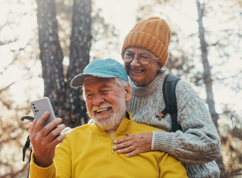 Cropped version of senior couple looking at phone in autumn