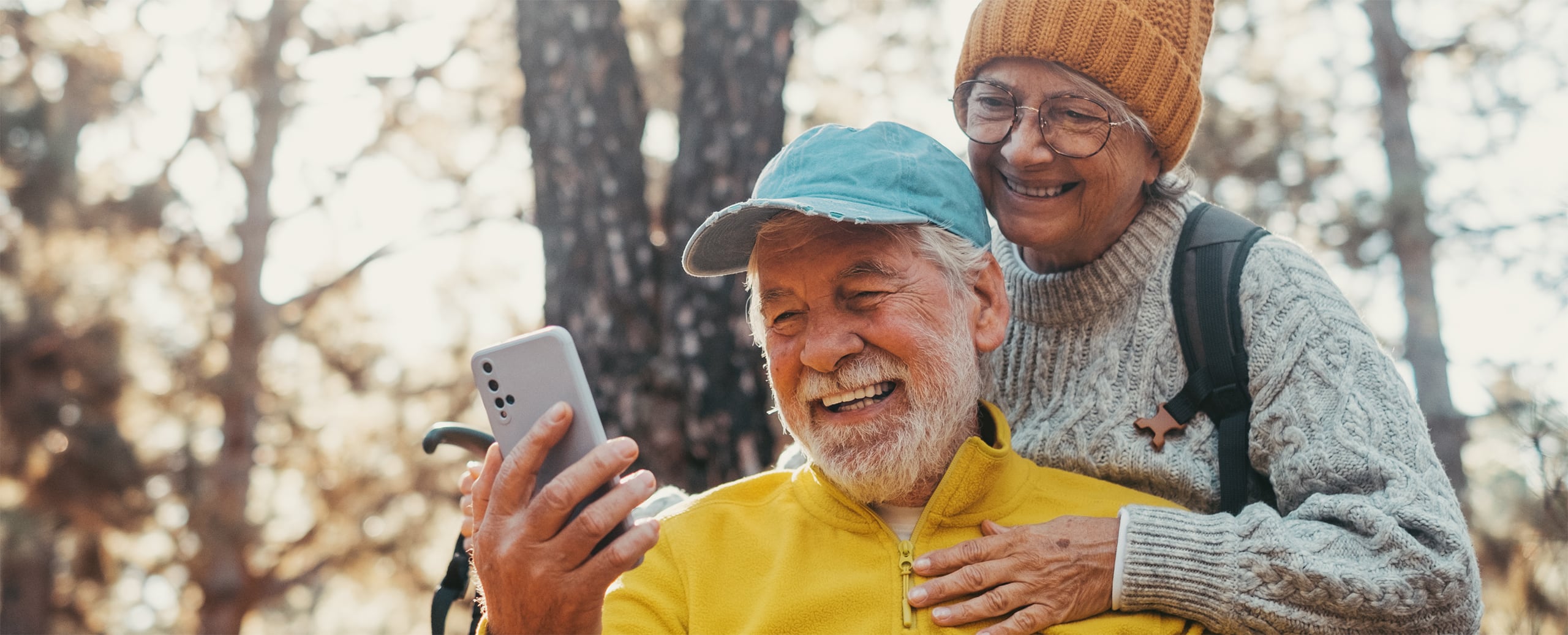 Senior couple looking at phone in autumn
